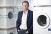 Posed photograph of AO.com chief executive John Roberts next to washing machines