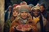 Waitrose Christmas ad still showing actress Ashley Jensen holding a plate of cold meat cuts in front of some carol singers