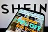 Shein website on phone with Shein logo in background