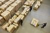 Workers moving boxes in a large warehouse