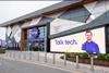 Exterior of Currys store. Sign shows an employee and reads: 'Talk tech.'