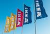 Five Ikea flags against a blue sky in yellow, red and blue
