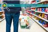 Man holding shopping basket with bread and milk groceries in supermarket