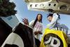 Two young people removing JD Sports carrier bags from a car boot