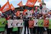 Asda workers on strike with flags and a cutout of TDR capital Manjit Dale