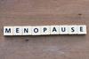 Scrabble letters spelling out 'Menopause' on a wooden background