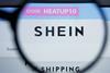 Shein logo on a computer screen behind a magnifying glass