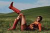 Model lying on grass and wearing red Hunter wellies
