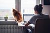 Woman working at home with cat on windowsill
