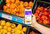 Customer holding phone in supermarket with Nectar app on screen