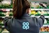 Co-op employee shown from behind in grocery aisle