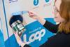 Woman placing Tesco Loop packet into recycling bin