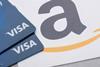 Close-up on Amazon logo with two Visa credit cards overlaying it