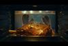 Still from Morrisons Christmas advert showing Union Jack oven gloves removing a turkey from the oven
