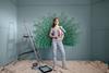 Woman holding a paint roller while decorating a room