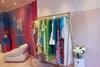 Racks of brightly coloured clothes in store at By Rotation, Belgravia