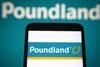 Close-up of Poundland logo on a phone in front of a background saying 'Poundland'