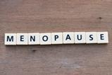 Scrabble letters spelling out 'Menopause' on a wooden background