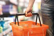 Shopper holding an orange plastic grocery basket