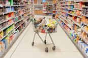 Supermarket trolley in middle of supermarket aisle