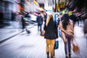 Two women pictured on busy blurred high street
