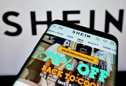 Shein website on photo in front of a Shein logo background