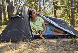 Woman sitting inside Mountain Warehouse tent