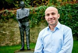 Rami Baitieh in front of Sir Ken statue