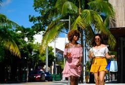Friends carrying shopping bags on a sunny street