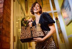 Model holding leopard-print handbag
