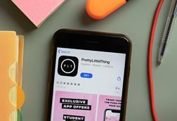 PrettyLittleThing app on a phone on a desk