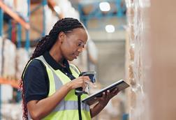 Warehouse worker using scanner and tablet