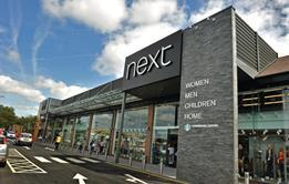 Next has reduced its profit expectations for the year after the unseasonably warm start to autumn hit sales growth in its third quarter.