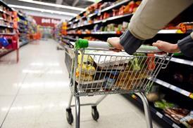 Customer pushing shopping trolley in supermarket