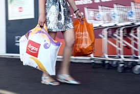 Shopper with Sainsburys and Argos carrier bags