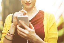 Woman looking at phone with headphones in