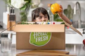 Child unboxing fruit from a HelloFresh delivery box