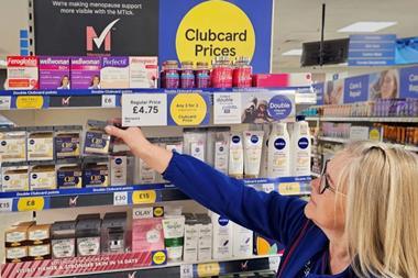 Woman reaching for a product inTesco with a sign reading: 'MTick – Menopause friendly'