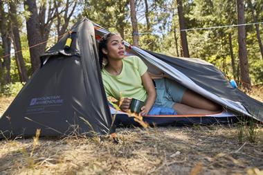 Woman sitting inside Mountain Warehouse tent