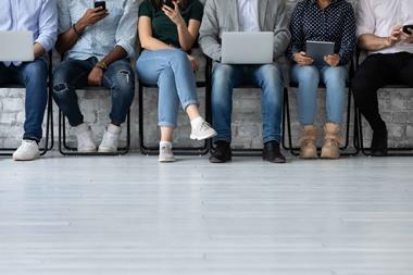 Six people queuing for job interview, seated, shown from head down