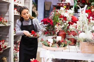 Christmas shop worker putting a plant pot on a display