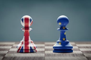 Two pawns on a chessboard, one painted with the Union Jack and one with the EU flag