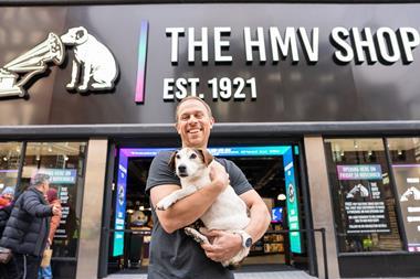 HMV owner Doug Putman poses with a dog outside HMV's Oxford Street store