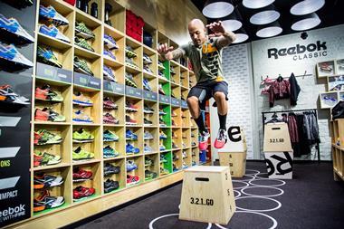 Man in gym kit jumping on box in a Reebok store