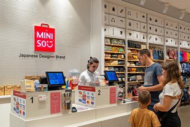 Employee at checkout in Miniso store