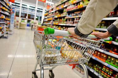Shopper pushing a supermarket trolley in an aisle