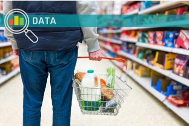 Man holding shopping basket with bread and milk groceries in supermarket