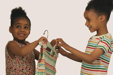 Two young female models exchanging an item of clothing between them