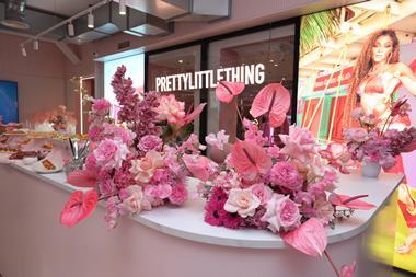 Reception desk at PrettyLittleThing, London, showing flowers and cakes on display