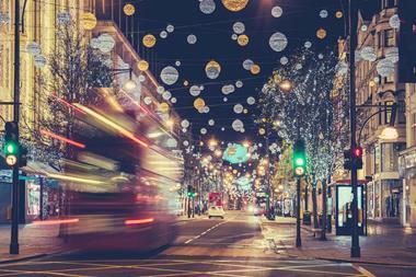Christmas scene in central London with lights and a blurred red bus